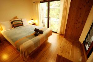 a bedroom with a bed with a teddy bear on it at Mt Warning Rainforest Park 