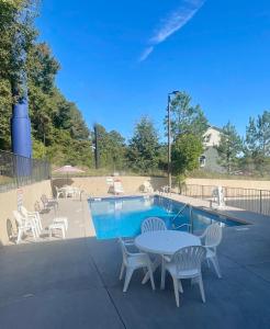 a swimming pool with a table and chairs next to it at Comfort Inn & Suites Augusta Fort Eisenhower Area in Augusta