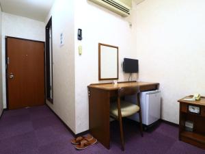 a room with a desk with a mirror and a sink at Shinseto Station Hotel in Seto