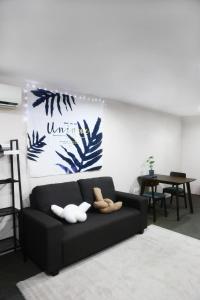 ein Wohnzimmer mit einer schwarzen Couch mit zwei Enten drauf in der Unterkunft Private GameRoom and Cinema at The CEO Penang in Bayan Lepas