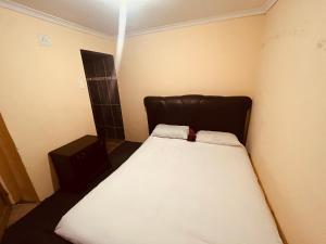 a small bedroom with a bed with a black headboard at Mphatlalatsane BnB in Maseru