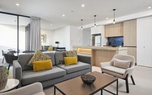 Il comprend un salon avec un canapé et des chaises ainsi qu'une cuisine. dans l'établissement Serain Residences on Qube, à Gold Coast