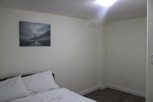 a bedroom with a bed with a picture on the wall at Comfyhome in Vaughan