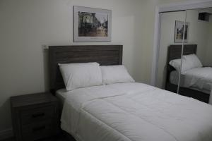 1 dormitorio con 1 cama grande y espejo en Comfyhome, en Vaughan