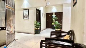 a hallway with chairs and plants in a building at Royal Inn Hotel in Karachi