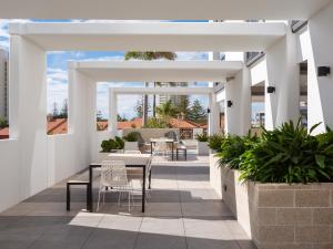d'une terrasse avec une table et des chaises. dans l'établissement Serain Residences on Qube, à Gold Coast