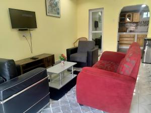 a living room with a couch and a tv at Faith and Grace Guest House in Lamin