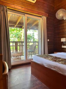 a bedroom with a bed and a large window at Jironi Resort in Charduār