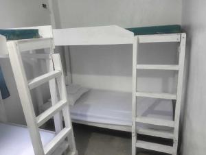 two white bunk beds in a small room at Alegreya Homestay + Cafe in General Luna