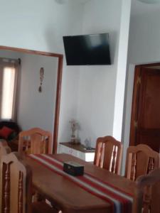 ein Esszimmer mit Tisch und Stühlen und einem Fernseher in der Unterkunft Vistas del Colorado in Cafayate