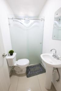 La salle de bains blanche est pourvue de toilettes et d'un lavabo. dans l'établissement HOSPEDAJE Y MIRADOR EL ANGEL, à Calvillo
