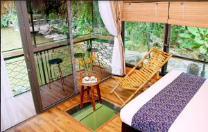 Habitación con 1 cama y 1 silla en el balcón. en Tam Coc Lion Kings Hotel & Resort en Ninh Binh