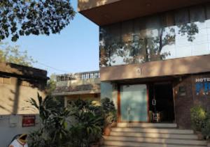 Ein Gebäude mit einem Haufen Treppen davor. in der Unterkunft Hotel Premier - Hotel in Saket Society Bhusawal in Bhusāwal