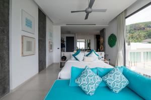 um quarto com uma cama grande e almofadas azuis em Villa Omari 5Bedroom with pool em Praia de Kata