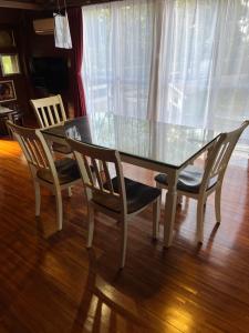 恩納村にあるヴィラフロムオキナワのガラスのダイニングテーブル(椅子2脚、ガラスのテーブル、2つのテーブル付)
