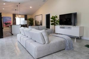 sala de estar con sofá y TV de pantalla plana en Palm Beach Getaway with hot tub & mini golf near beaches, downtown, and plenty of shopping, en West Palm Beach