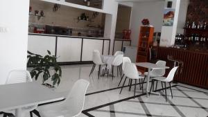 a dining room with white tables and white chairs at Danakil Hotel in Addis Ababa