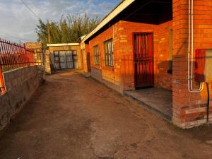 a brick building with a red door on the side of it at Mphatlalatsane Executive BnB in Maseru