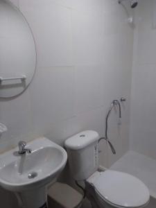 a white bathroom with a toilet and a sink at Casa de playa Briceño// Beach house Briceño in Briseño