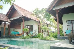 een huis met een zwembad ervoor bij Villa Puri Kembar in Ubud