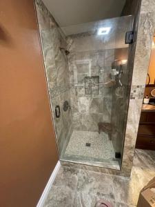 La salle de bains est pourvue d'une douche avec une porte en verre. dans l'établissement Luxury Cozy Studio with Firepit, à Vista