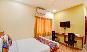 1 dormitorio con 1 cama y escritorio con ordenador en FabHotel Kamala Inn en Kotrung