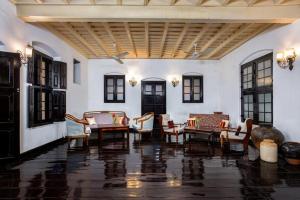 a living room with chairs and tables in a building at Koder House in Cochin