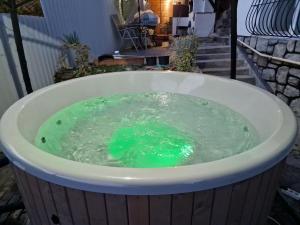 uma banheira de hidromassagem cheia de água verde em Casa Aurora em Călimăneşti