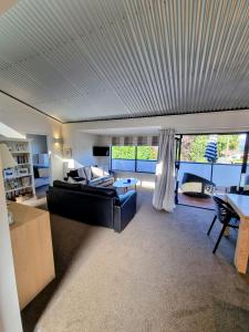 a large living room with a bed and a table at Cottage on Matai in Wanaka