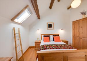 a bedroom with a bed with orange pillows and a window at Dowlod y Gelli in Trawsfynydd