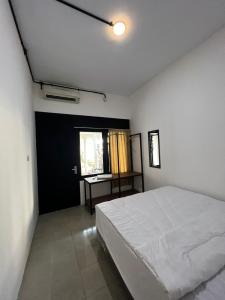 a bedroom with a white bed and a window at White House Malioboro in Jetis