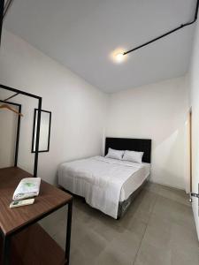 a white bedroom with a bed and a table at White House Malioboro in Jetis