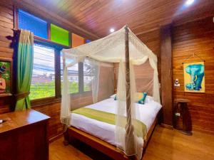 sypialnia z łóżkiem z baldachimem i oknem w obiekcie 泰小院儿（99 Friend’s house Lanna ) w mieście Chiang Mai