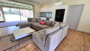 ein Wohnzimmer mit einem Sofa und einem Tisch in der Unterkunft Unwind On Ellmoos in Sussex inlet
