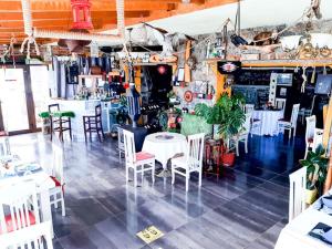 een restaurant met witte tafels en stoelen in een kamer bij Hotel Villa Stone Dream Bar Restaurant in Pogradec