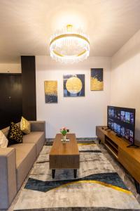 uma sala de estar com um sofá e uma televisão em Luxury Gold Apartment 86 : D1- Mension , Rooftop Pool - District 1 em Ho Chi Minh