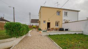 ein gelbes Haus mit einem Garten und einer Terrasse in der Unterkunft Comme a la maison in Saint-Julien-les-Villas