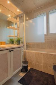 ein großes Bad mit einer Badewanne und einem Waschbecken in der Unterkunft Comme a la maison in Saint-Julien-les-Villas