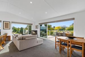 un soggiorno con divano e tavolo di Scenic Lake Views - Taupo Holiday Home a Taupo
