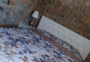 een slaapkamer met een bed en een stenen muur bij Hotel Villa Stone Dream Bar Restaurant in Pogradec