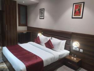 a hotel room with a bed with red and white pillows at Hotel THE LAMP in Zirakpur