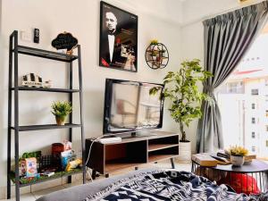 a living room with a tv and a shelf at 9 pax Homestay near Axiata Arena & Pavilion 2 in Kuala Lumpur