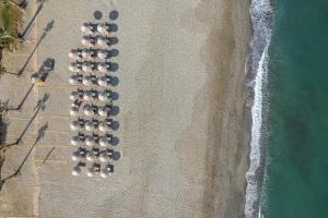 uma vista superior de uma linha de guarda-sóis na praia em Aristea Hotel em Rethymno Town