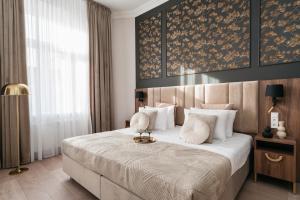 a bedroom with a large bed with white pillows at White Lotus - LoftAffair Collection in Kraków