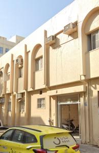 a yellow car parked in front of a building at orange hostel in Dubai