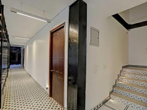 een hal met een houten deur en een tegelvloer bij OYO Hotel Expo View Stay in Noida