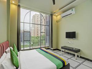 een slaapkamer met een bed en een groot raam bij OYO Hotel Expo View Stay in Noida