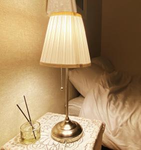 een lamp op een tafel naast een bed bij Sarangchae Yeonsu 2 in Incheon