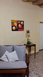 un sofá en una sala de estar con una pintura en la pared en BYLELA en Tinogasta