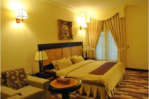 een slaapkamer met een groot bed en een bank bij Capital O 155 Dmas Hotel in Muscat